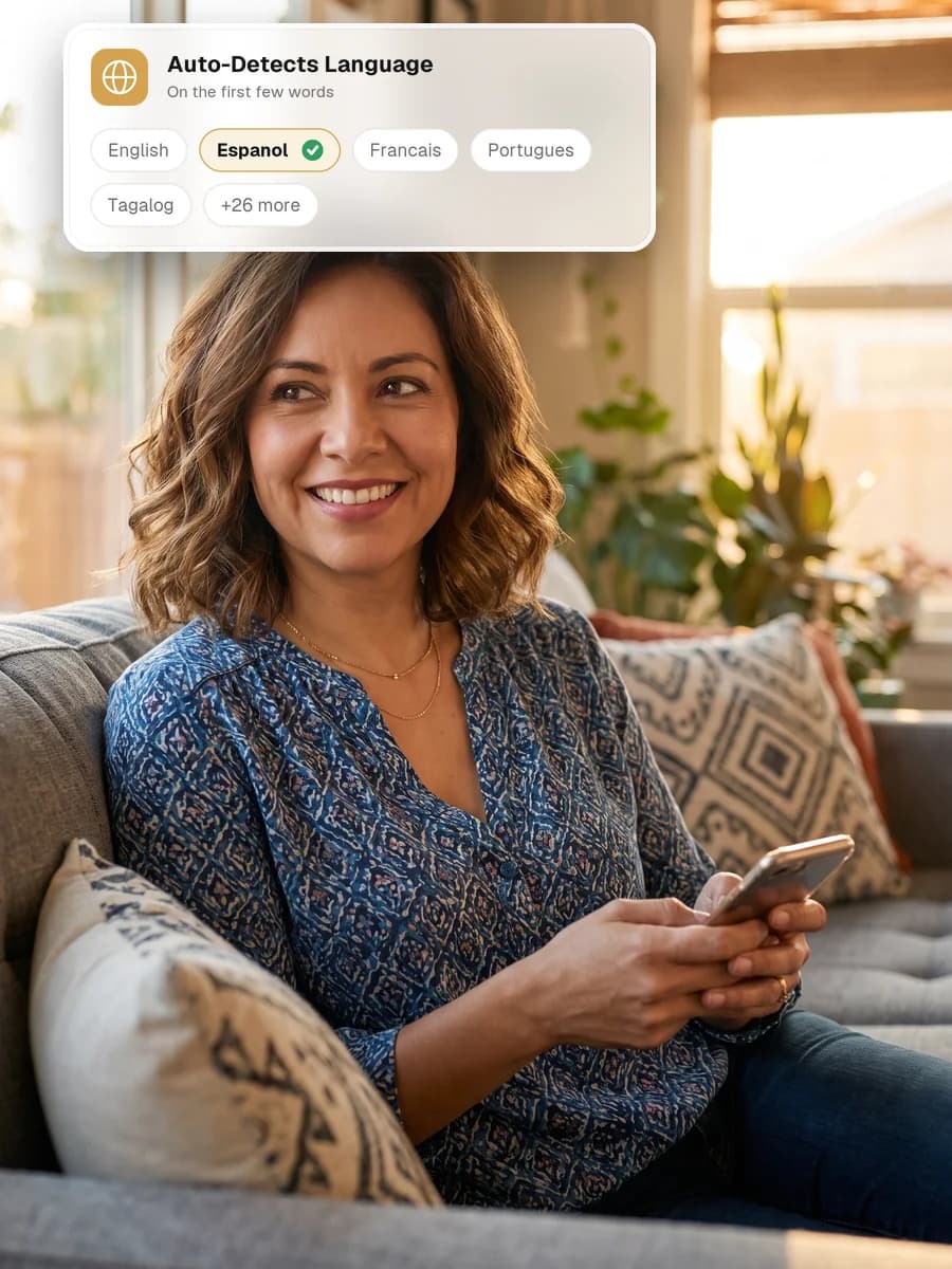 A woman smiling at home while using her phone